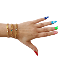 a woman's hand with colorful nails and a gold bracelet