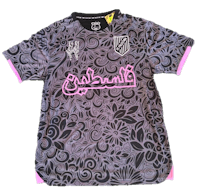 a black and pink soccer jersey with a floral design