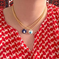 two evil eye necklaces on a woman's neck