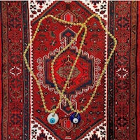 two evil eye necklaces on a rug